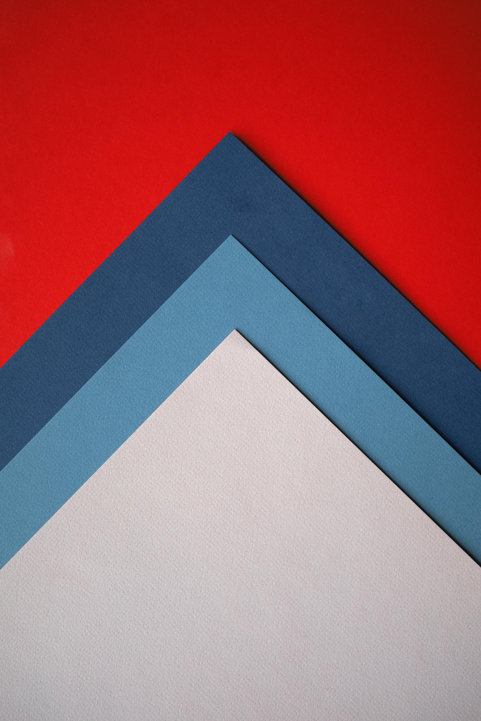 Colourful layers of paper in 3 shades of grey and 1 red shade.